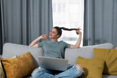 Genç, mutlu bir kadın, hastane laboratuvarından göğüs kanseri testi ve sağlık sigortası konseptiyle ilgili negatif tıbbi sonuçlar alan bir e-posta aldıktan sonra evinde dinleniyor.