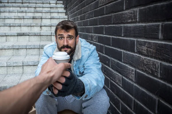 Hand Giving Cup Coffee Young Hungry Homeless Man Sitting Stairs — Stock Photo, Image