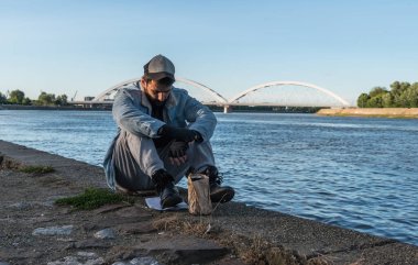 Depresyonda olan sarhoş evsiz adam köprünün altında oturmuş alkol içiyor ve intihar etmek için nehre atlayıp hayatını sonlandırmayı düşünüyor.