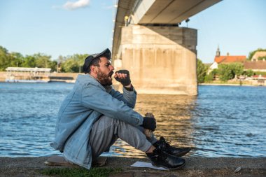 Depresyonda olan sarhoş evsiz adam köprünün altında oturmuş alkol içiyor ve intihar etmek için nehre atlayıp hayatını sonlandırmayı düşünüyor.