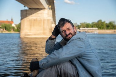 Depresyonda olan alkolik evsiz bir adam köprünün altında oturup alkol içerek uyuduktan sonra yüzünü güneş ışığından korumaya çalışıyor ve daha fazla içmek için uyanıyor, sosyal belgesel.