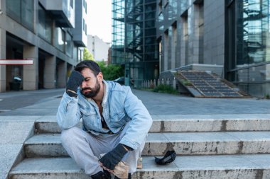 Genç bunalımlı evsiz adam caddenin karşısındaki merdivenlerde oturuyor. Sarhoş olmak için bir kutu içki açıp umutsuz hayatını, sosyal belgesel konseptini unutuyor.