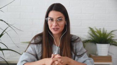 Genç tatmin olmuş serbest çalışan iş kadını dizüstü bilgisayarında şirket çalışanlarının piyasa stratejisinde başarılı liderlik için fikir ve çözümleri açıkladığı bir video sunumu yapıyor.