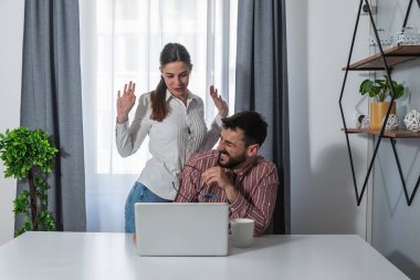 Genç, başarılı ve mutlu iş arkadaşları bir erkek ve bir kadın iş yerinde oturmuş şakalar yapıyor ve iş yerinde gülüyorlar. Çalışırken boş zamanlarını daha iyi değerlendirmek için.