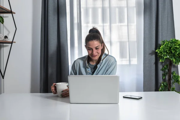 Genç bir kadın. Psikoterapi uzmanı. Hastasıyla çevrimiçi psikoterapi görüyor.