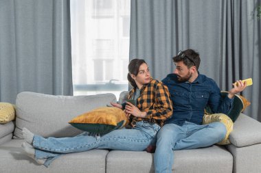Evde oturan genç çiftin, sosyal medya ağları aracılığıyla akıllı telefonlarda sohbet ve flörtleşmenin yol açtığı kıskançlık, ilişki sorunları ve güvensizlik nedeniyle sorunları var ve tartışıyorlar.