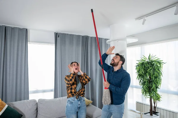 Genç çift tavana bakıp bağırıyor çünkü üst kattaki bir komşu gürültülü bir parti veriyor ya da apartman dairesini yeniliyor ve işçiler ağır aletlerle sondaj yapıyorlar.