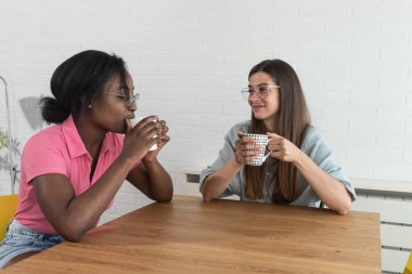 Bir web geliştirme şirketinde çalışan iki genç bayan bir siyah ve beyaz kadın kahve molası verip özel hayatları ve şirketin geleceği ve işi hakkında konuşuyorlar.