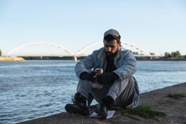 Genç, üzgün ve bunalımlı bir adam nehir kenarında oturmuş alkol içiyor, kendini perişan hissediyor ve dünyadan ve aileden terk edilmiş hissediyor.