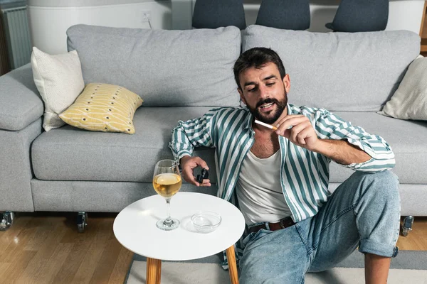 Giovane Uomo Spensierato Seduto Sul Pavimento Della Sua Casa Accendendo — Foto Stock