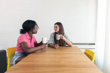 Aynı daireyi kiralayan, aynı masaya oturup kahve içen, küçük şeylerden bahseden ve günün tadını çıkaran iki genç bayan oda arkadaşı.