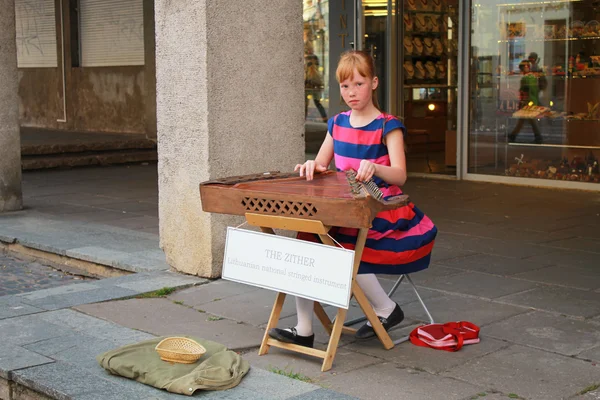 Ulicy młody muzyk dziewczyna siedzi na ulicy, Vilnius — Zdjęcie stockowe