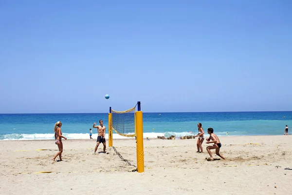 Jóvenes turistas jugando voleibol en la playa de arena en Creta, Grecia —  Fotos de Stock