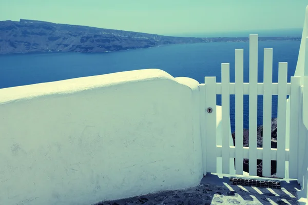 Pequena cerca branca portão e vista para o mar em Oia na ilha de Santorini — Fotografia de Stock