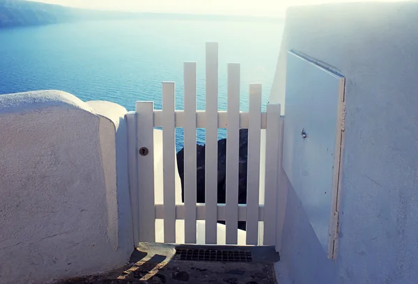 Puerta pequeña cerca blanca en Oia en la isla de Santorini, Grecia . — Foto de Stock