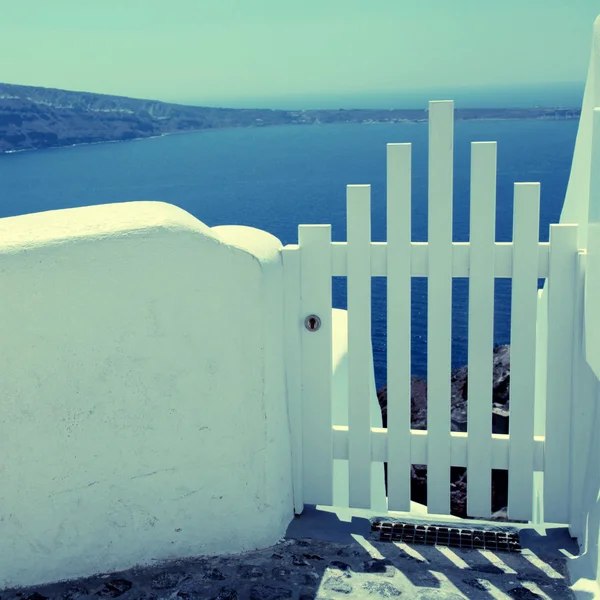 Puerta pequeña cerca blanca y vista al mar en Oia en la isla de Santorini , —  Fotos de Stock