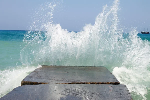 Sten breakwater med bryde bølger . - Stock-foto