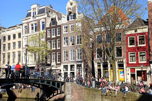 Молодежь отдыхает вдоль канала в Амстердаме, Нидерланды . — стоковое фото