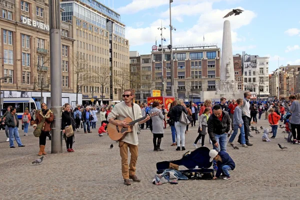 Street musician and tourists on Dam square, Amsterdam, Netherlands — Stock Photo, Image