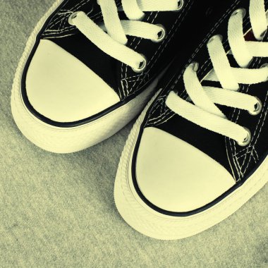 Tekstil gri arka plan üzerinde siyah tuval spor ayakkabı