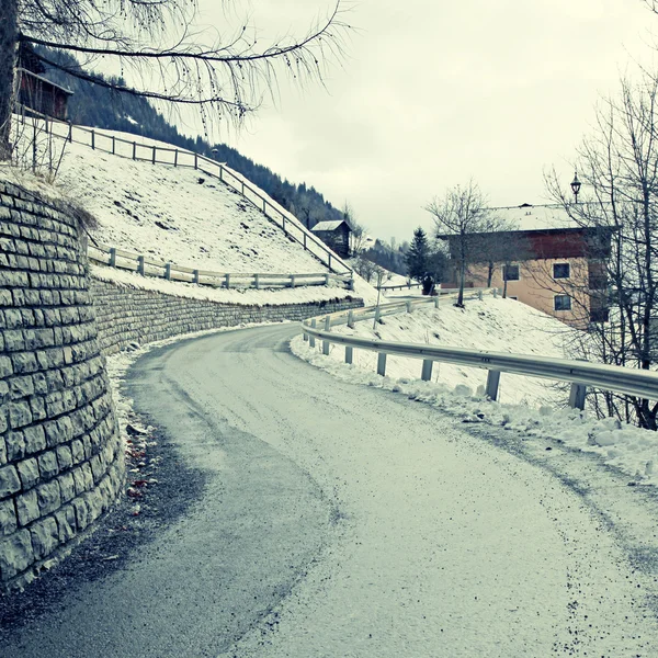 Gebogen landweg in winter Alpen — Stockfoto