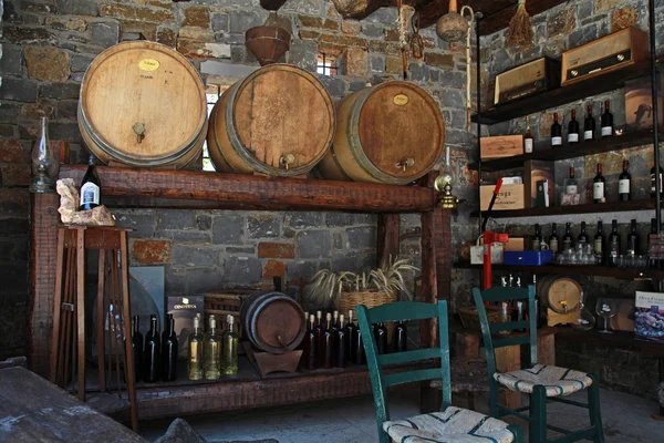 Винні бочки і пляшки в старому підвалі виноробні . — стокове фото