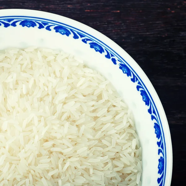 Blue bowl of uncooked white rice — Stock Photo, Image