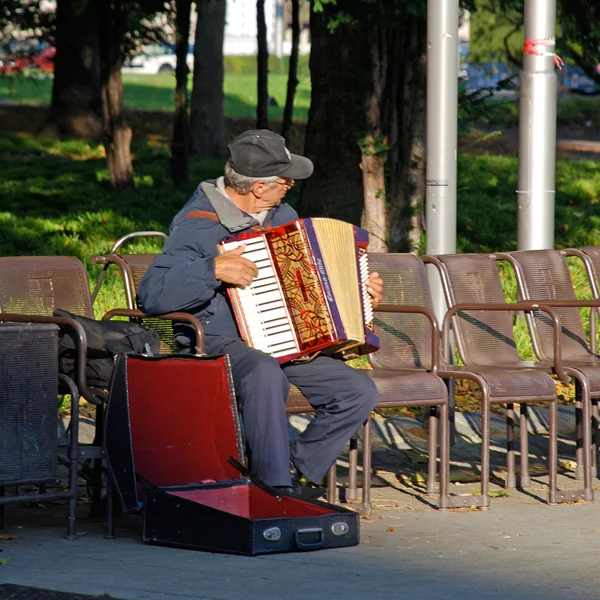 Dragspels-spelare sitter på bänken i city park, Wien, Österrike. — Stockfoto