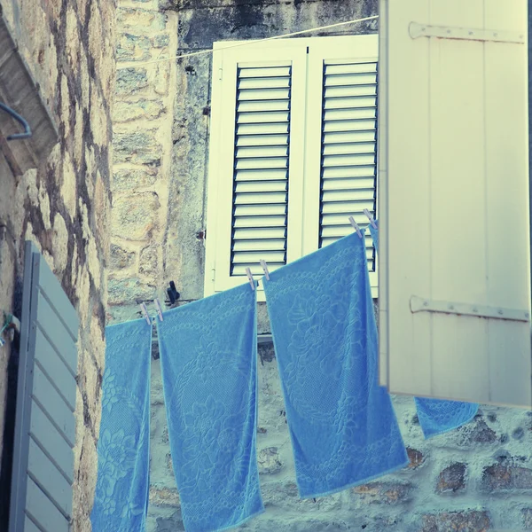 Altes Fenster mit Rollläden und blauer Wäsche — Stockfoto