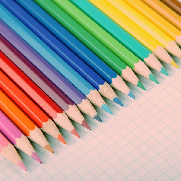 Crayones multicolores sobre fondo de papel cuadrado blanco . —  Fotos de Stock