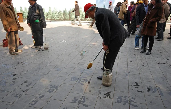 Unidentified man paints Chinese characters caligraphy — Stock Photo, Image
