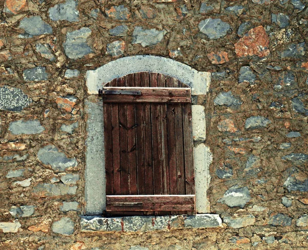 Ruwe houten luiken in oude stenen muur — Stockfoto
