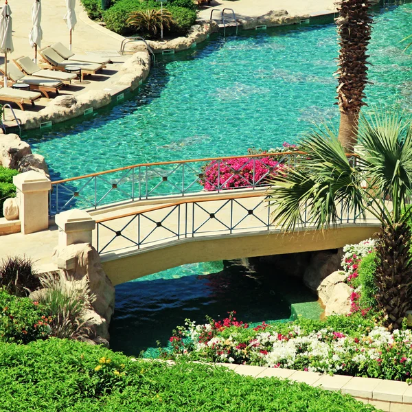 Belle piscine avec chaises longues, pont et flotteur — Photo