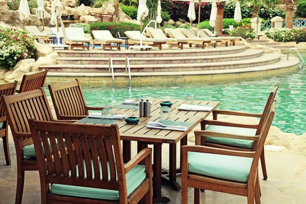 Mesa y sillas en la cafetería al aire libre al lado de la caca de natación resort — Foto de Stock