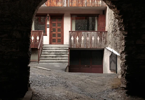 Välvda vy av gamla hus med träbalkong, Bormio, Italien — Stockfoto