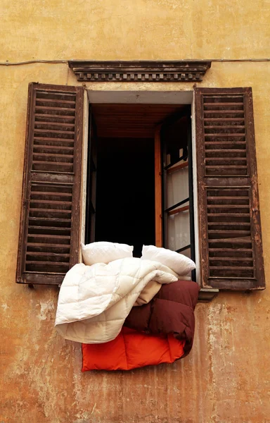 Oude luiken venster met beddengoed, Italië — Stockfoto