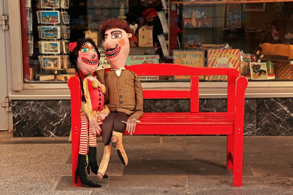 Bonecas amantes artesanais no banco vermelho, Bratislava, Eslováquia . — Fotografia de Stock