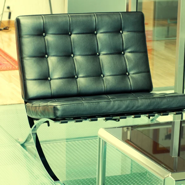 Black modern armchair on glass floor — Stock Photo, Image