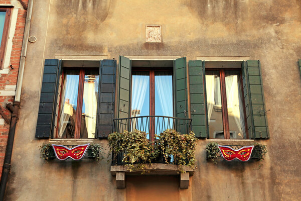 Traditional windows with green shutters of typical old Venice building ,Italy.