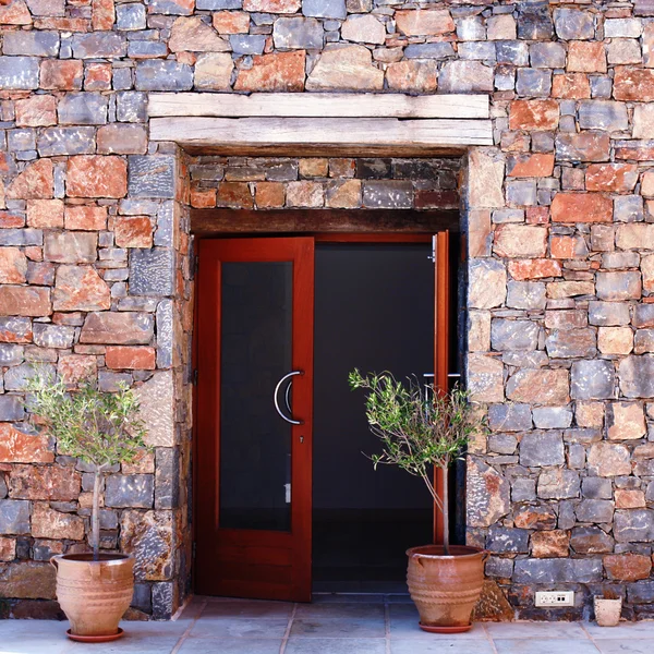 Open door and stone medanean wall (Greece ) — стоковое фото