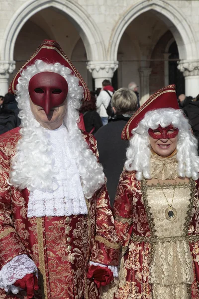 Masked persons in magnificent red and gold costume on San Marco — Stock Photo, Image