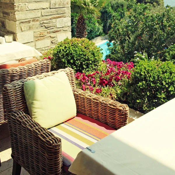 Poltrona in vimini sulla terrazza con vista sul mare e sul giardino (Greec — Foto Stock