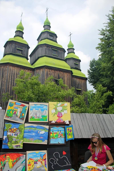 Ukrainian artist near wooden orthodox church in Museum Pirogovo,Kiev — Stock Photo, Image