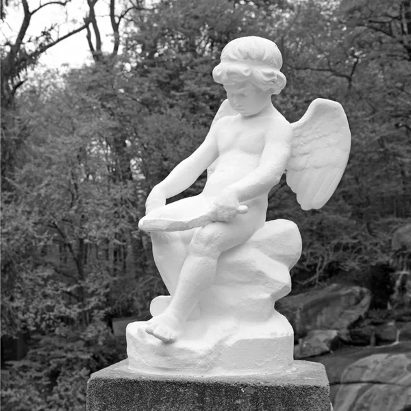 Статуя белого мрамора ангела-младенца в парке — стоковое фото
