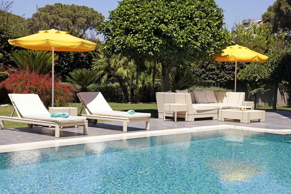 White outdoor furniture in the garden near the resort pool — Stockfoto