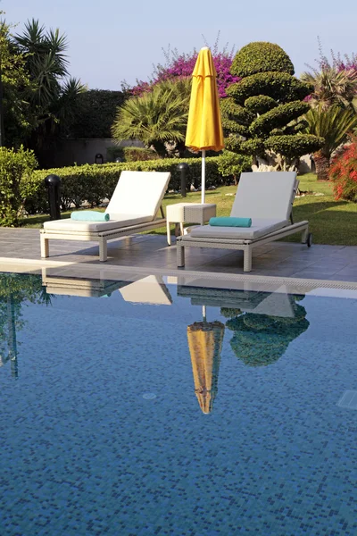 Weiße Gartenmöbel und gelber Regenschirm in der Nähe des Schwimmbades — Stockfoto