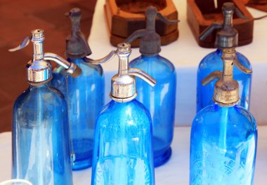 Antique blue soda syphon bottles on flea market  clipart