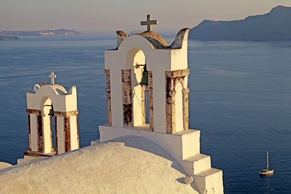 Колокольня старой белой церкви над красивым голубым морем, Ия — стоковое фото
