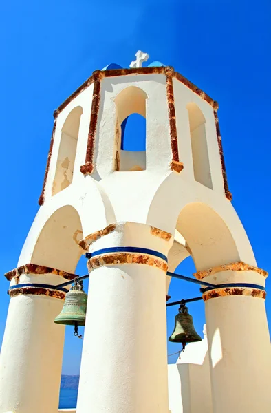 Glockenturm der weißen Kirche auf blauem Himmelhintergrund, oia, santorin — Stockfoto