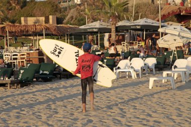  Herzliya plajda sörf tahtaları tutan genç sörfçü, İsrail. 